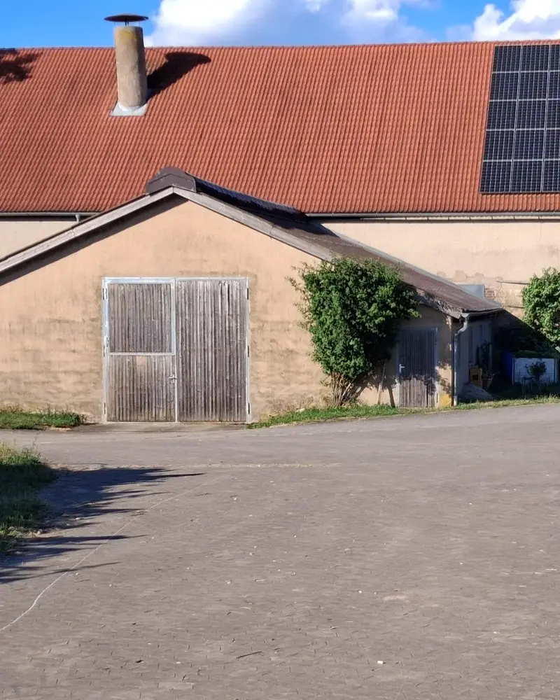 Bauernhof Gößwein mit Kühen auf der Weide, Scheunen und Traktor