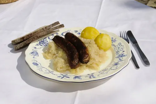 Gebratene fränkische Bratwürste mit Sauerkraut, Kartoffelklößen und Bauernbrot