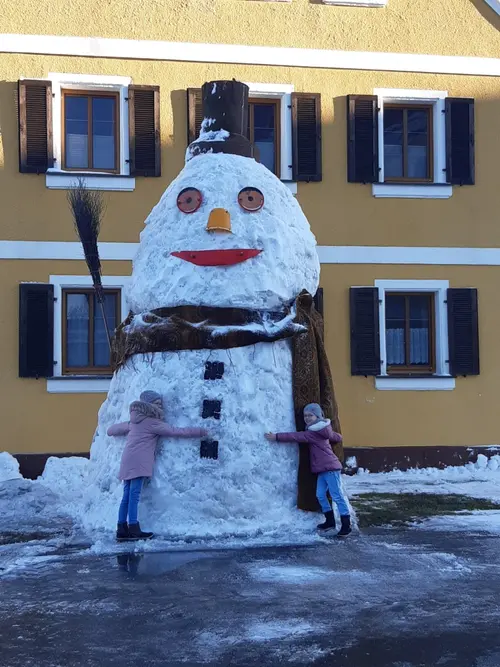 Verschneiter Hof im Winter mit Schneemann
