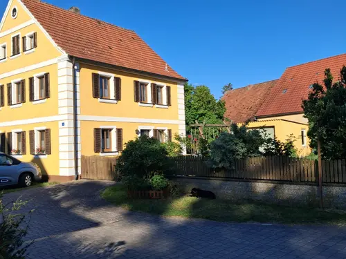 Gelbes fränkisches Wohnhaus des Hofs Gößwein im Abendlicht